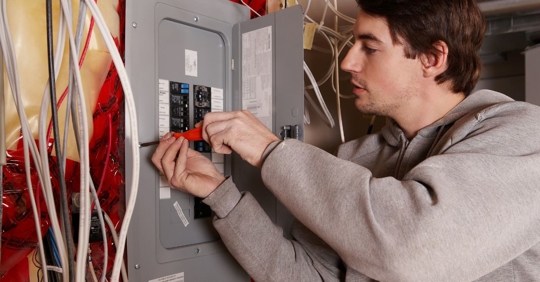 man adjusting electrical panel