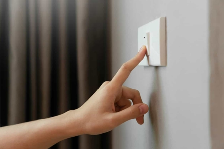 hand pointing on a light switch
