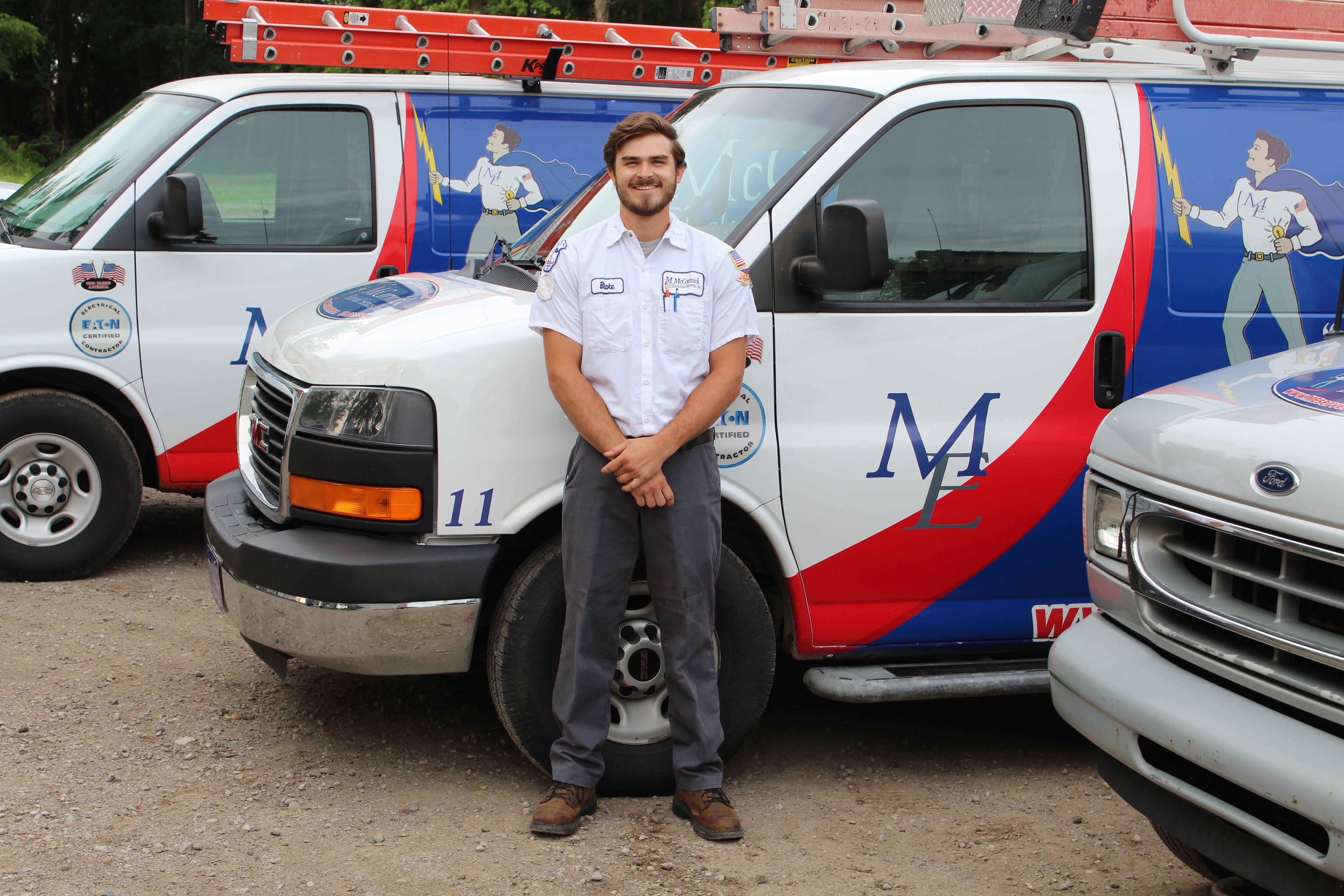 Alexander wearing a McCormick Electrical Services Inc. uniform and looking at the camera